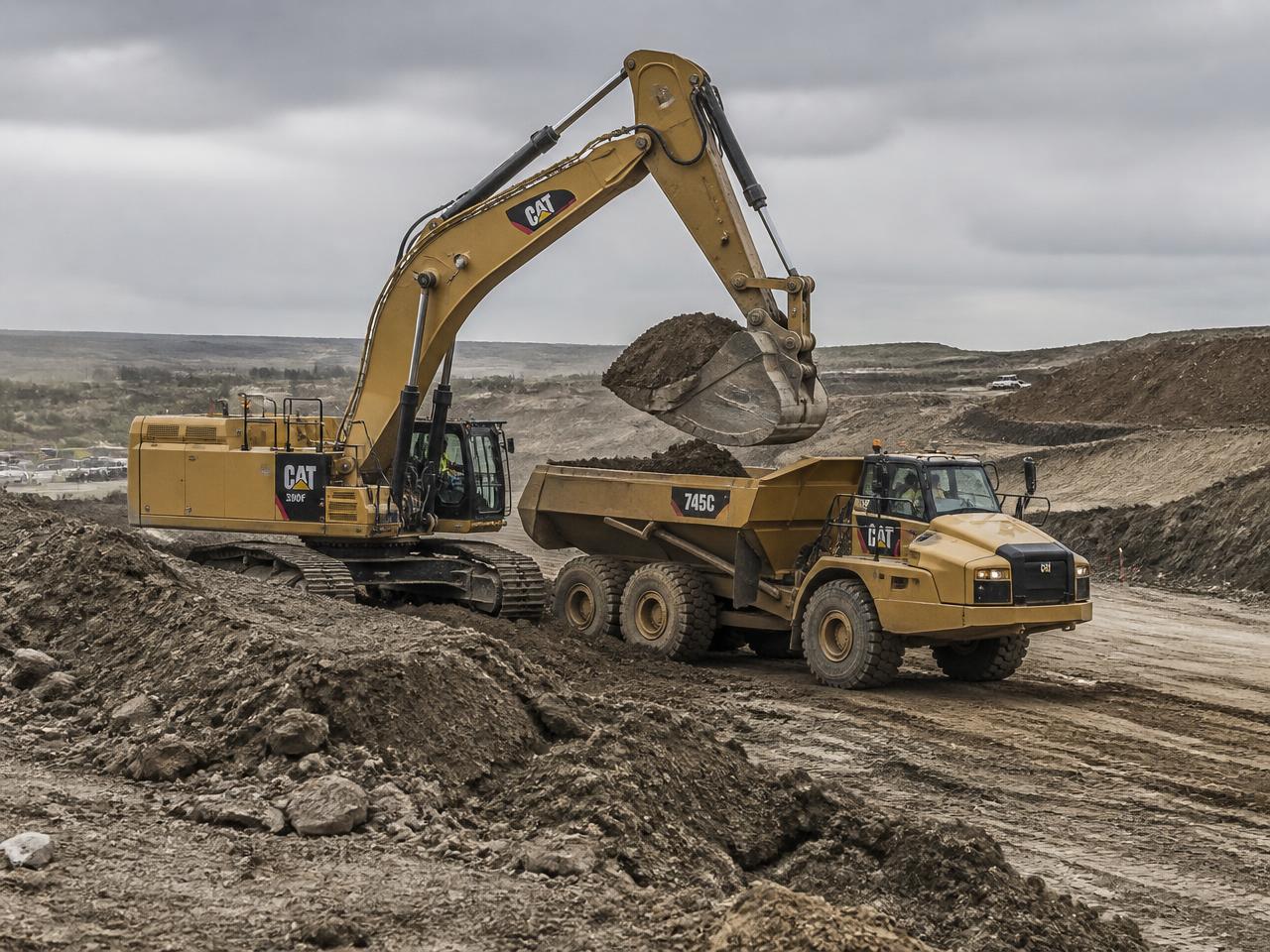 Tracked excavator loading an articulated dump truck on an earthworks site